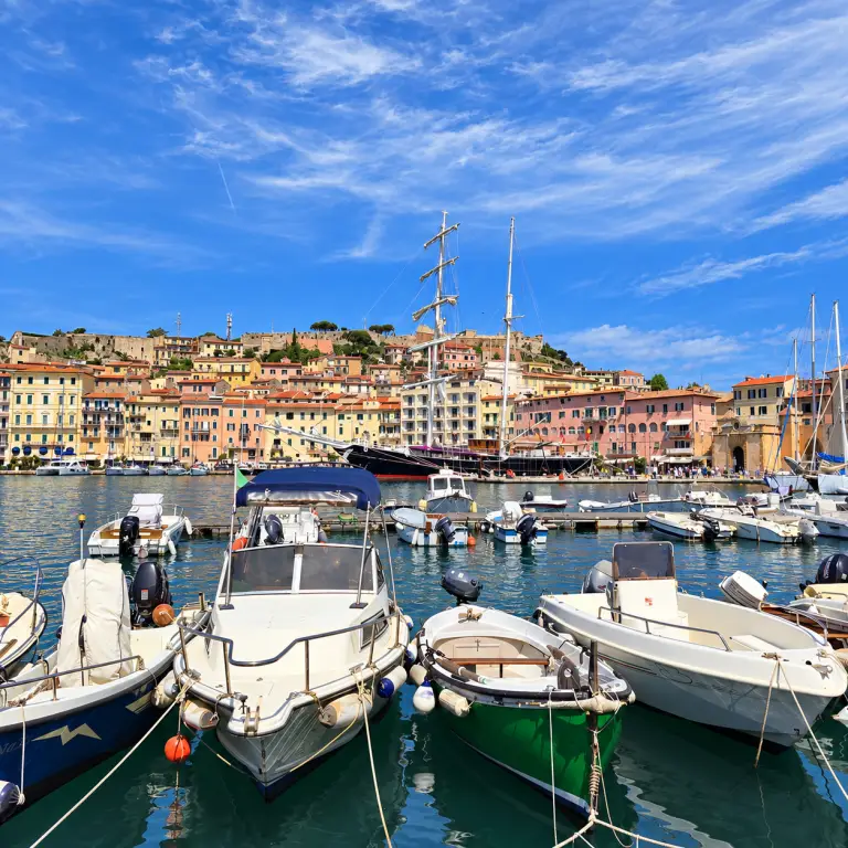 Barques dans le port de Portoferraio face aux façades colorées de l’Île d’Elbe.