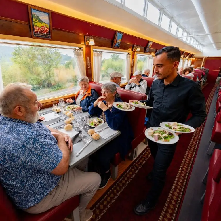 Voyageurs déjeunant dans la voiture-restaurant du Train à Vapeur des Cévennes