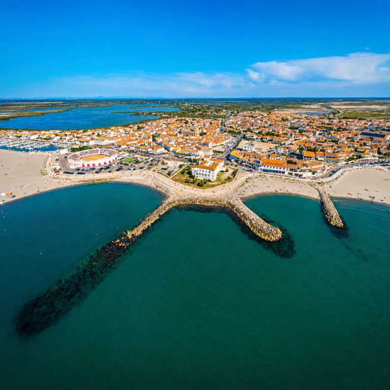 Vue aérienne des Saintes-Maries-de-la-Mer entre plage, port et Camargue