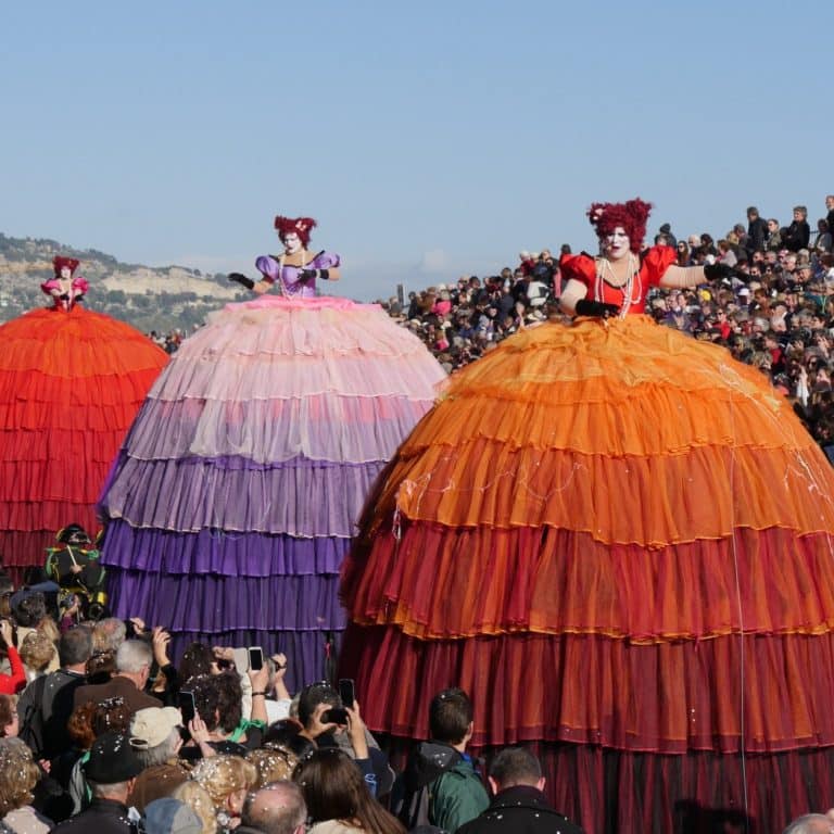 Artistes costumés devant les tribunes pendant le Corso de la Fête du Citron à Menton