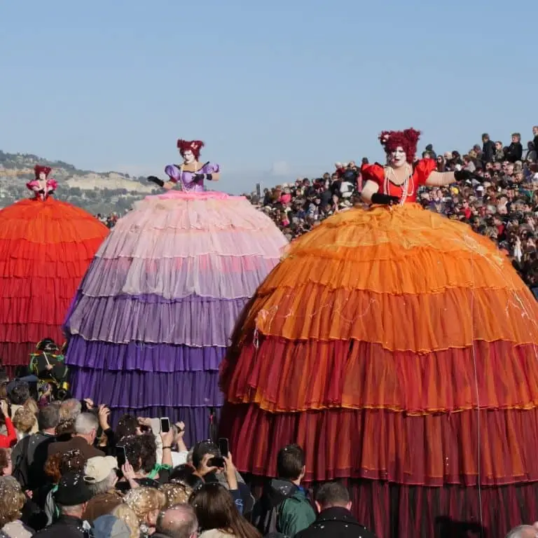 Artistes costumés devant les tribunes pendant le Corso de la Fête du Citron à Menton
