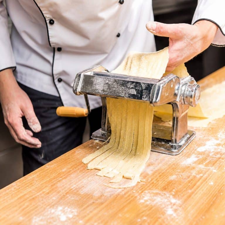 Préparation artisanale de pâtes fraîches italiennes à la machine.