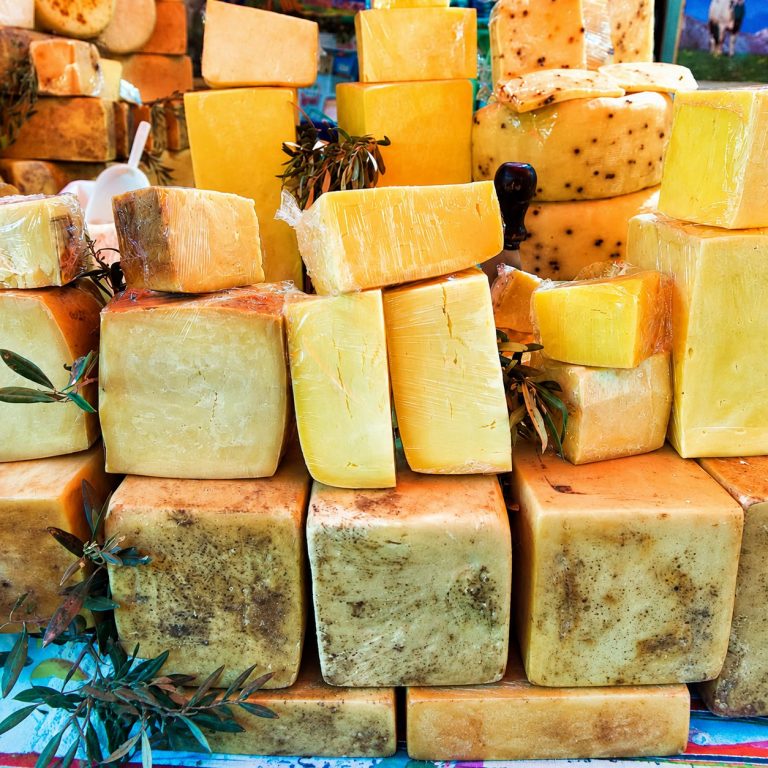 Étal de fromages italiens sur un marché traditionnel en Ligurie.