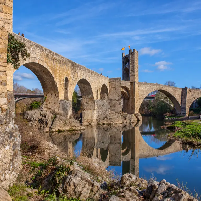 Pont médiéval fortifié de Besalú se reflétant dans la rivière Fluvià en Catalogne.