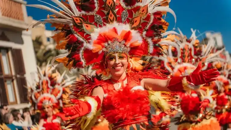 Danseuse en costume rouge et orange lors du Carnaval de Lloret de Mar sur la Costa Brava.